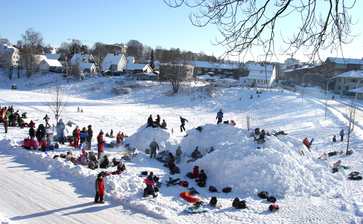 Barn som leger i snøen i Enenda. Foto