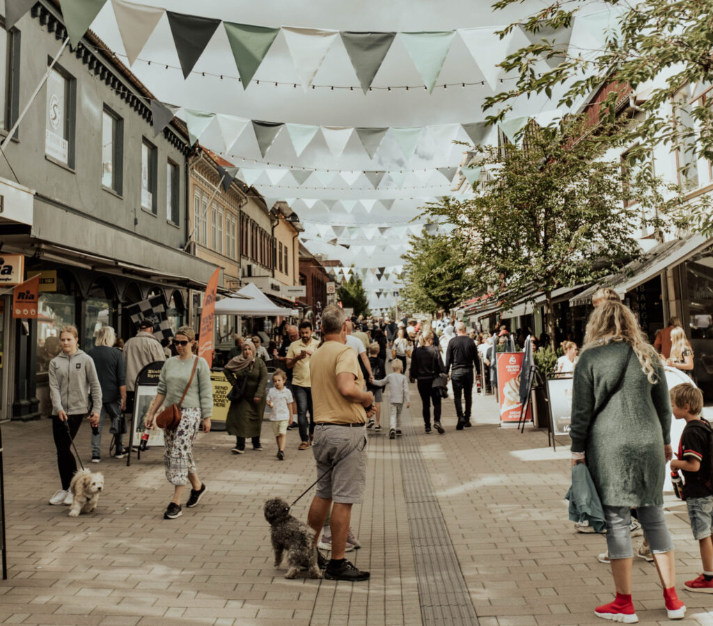 Gågaten i Sarpsborg fylt med mennesker og pynt. Foto.