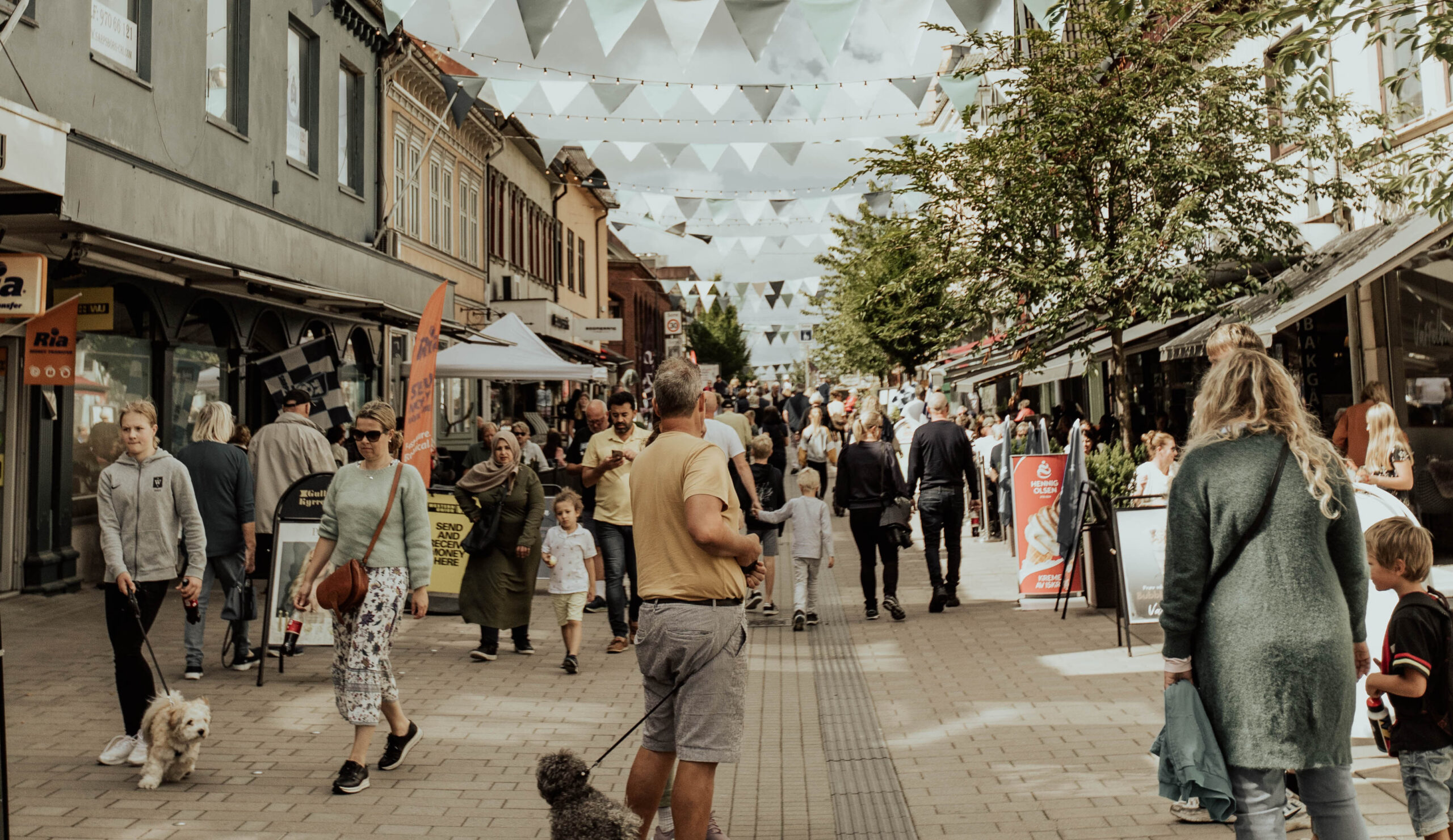 Mennesker, boder og pynt i gågata i Sarpsborg. Foto.
